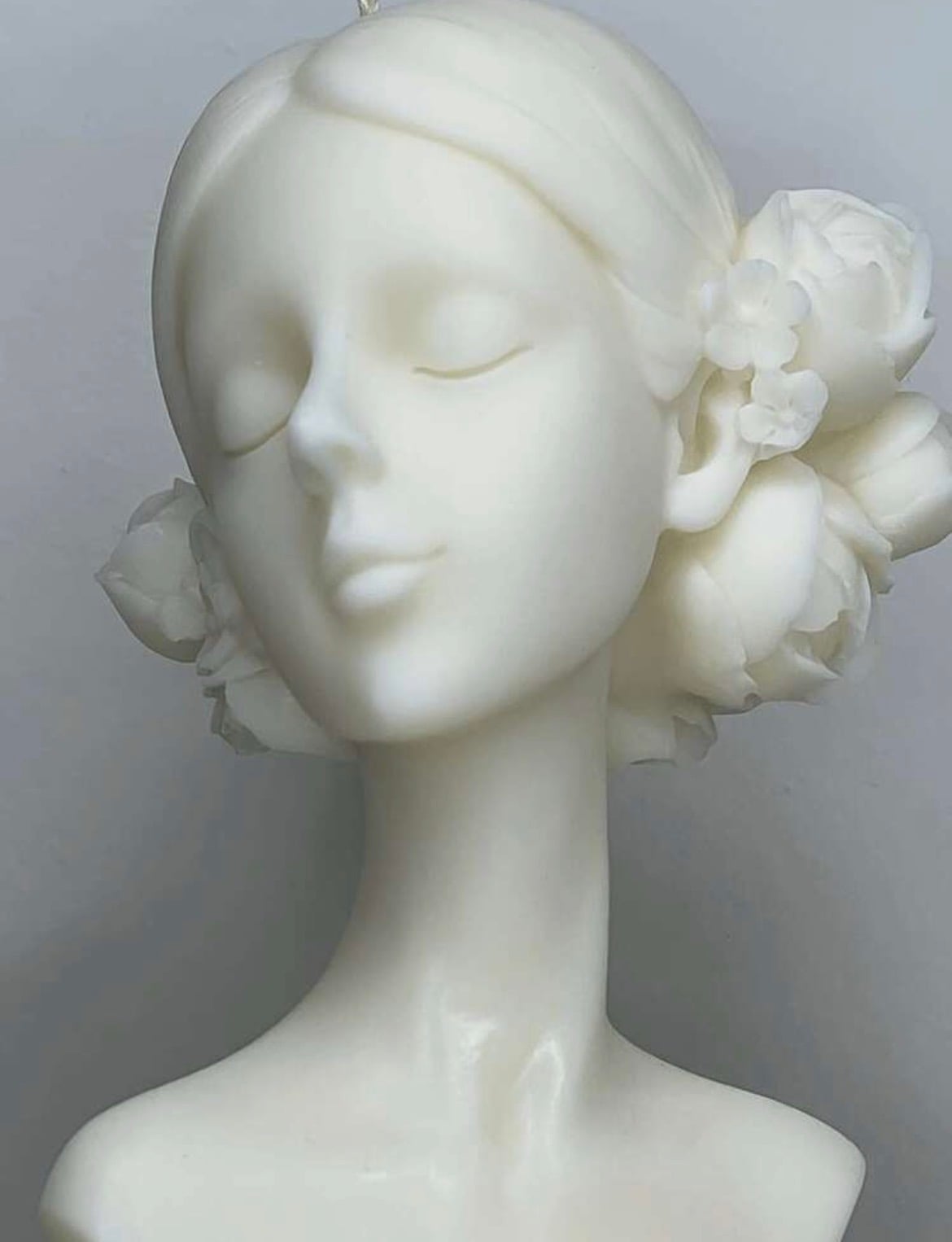 A bust candle with flowers in the hair