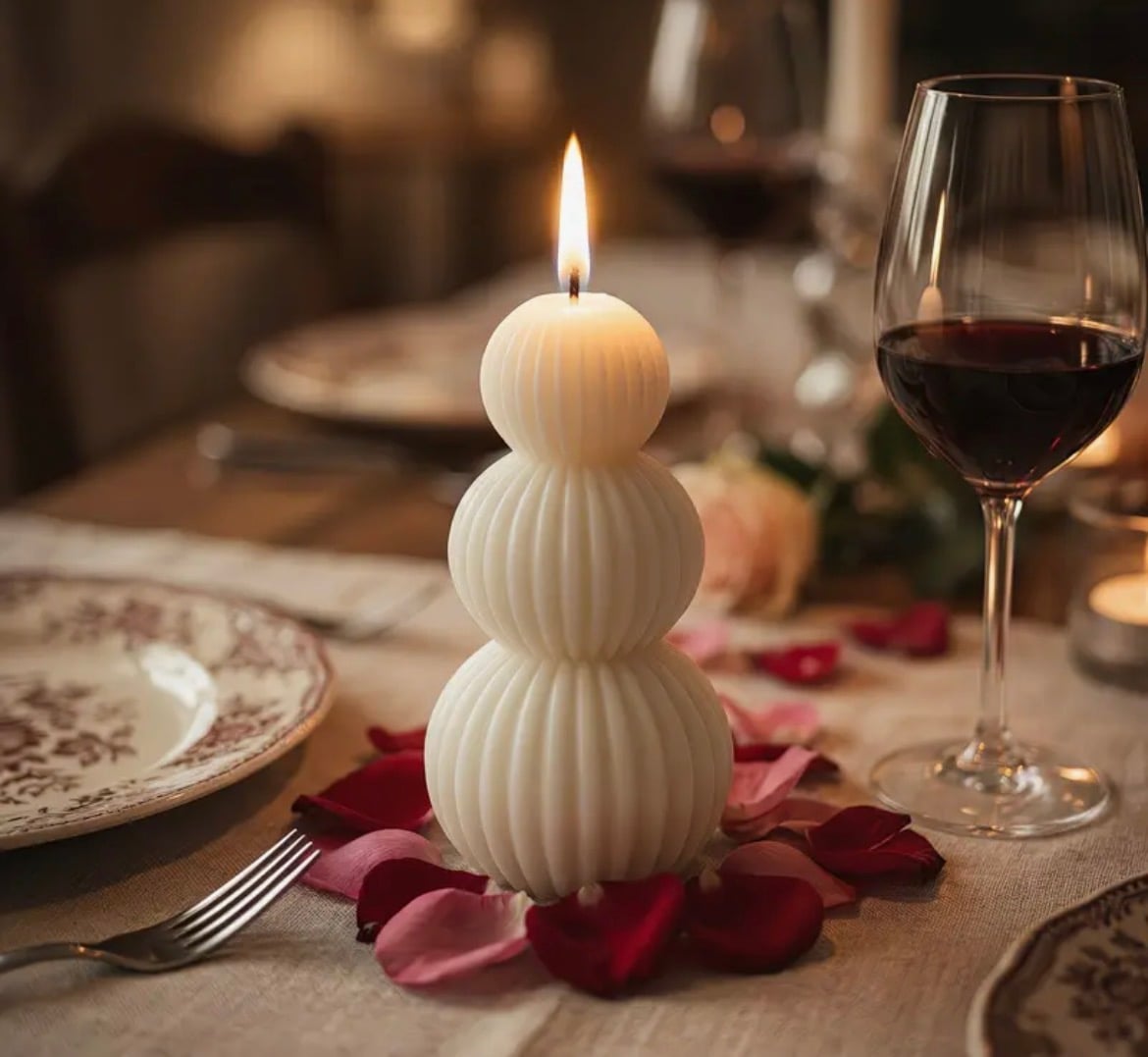 Lit triple-sphere ribbed candle on a dinner table