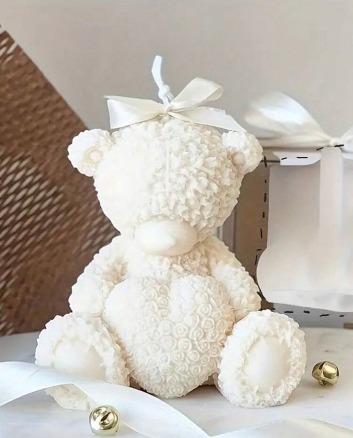A rose-textured teddy bear candle with a bow