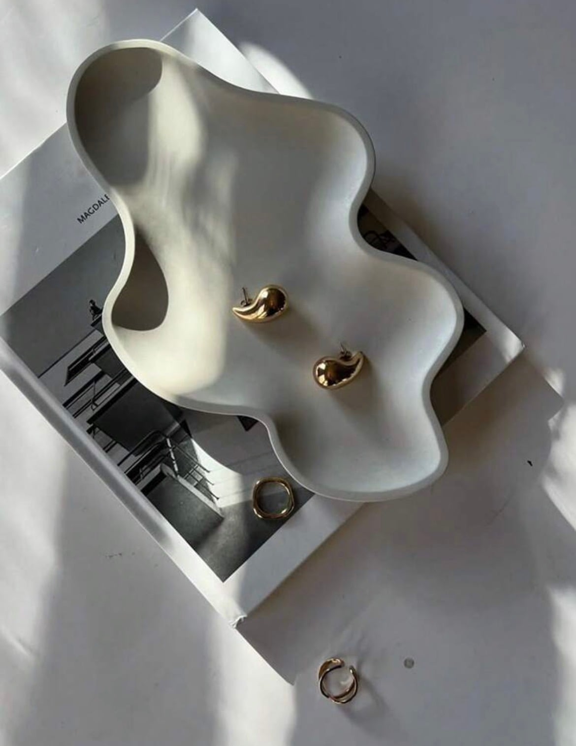 Organic wave-edged plaster platter with a travertine finish