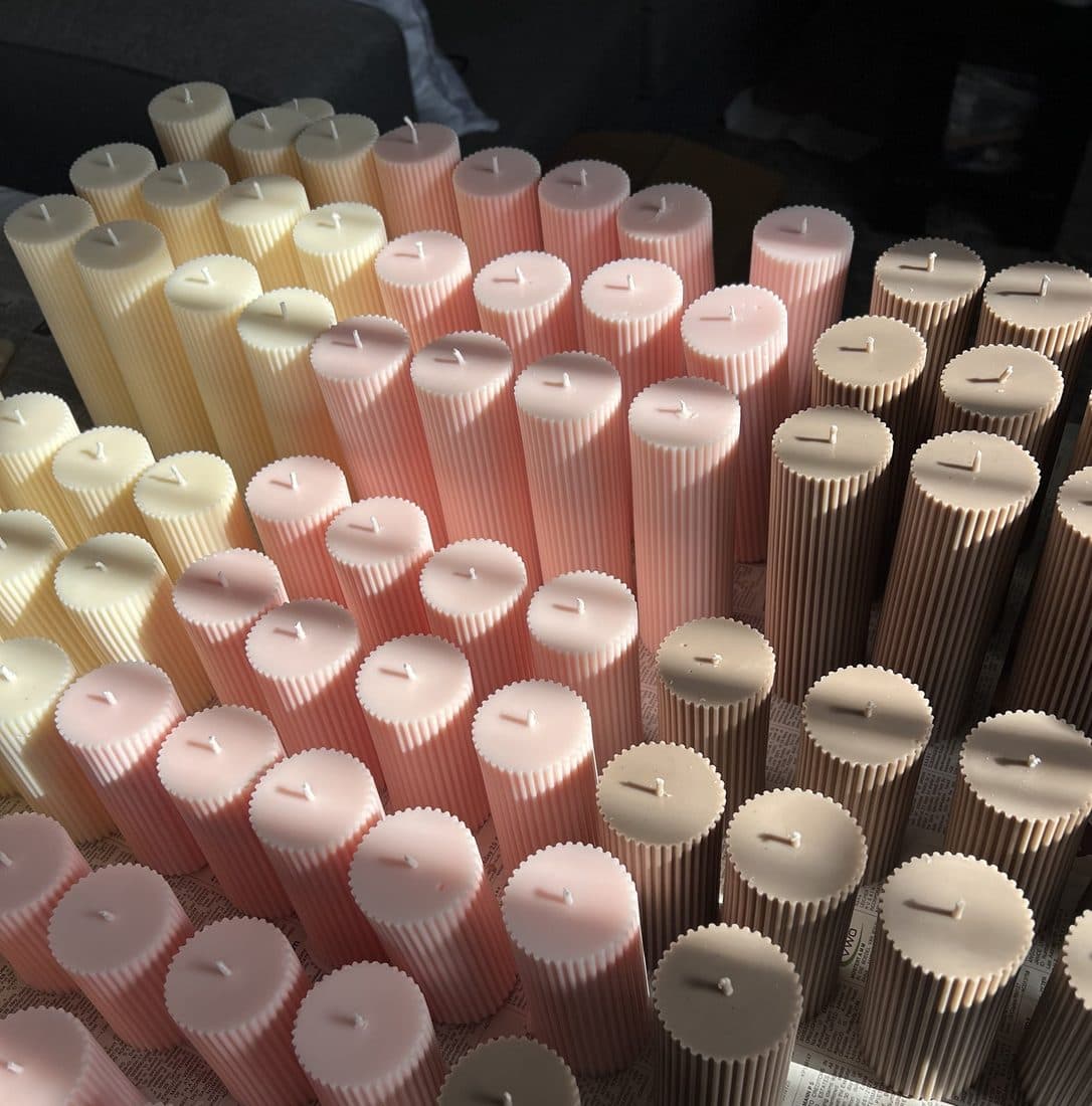Close-up of ribbed pillar candles in cream, blush and mocha in morning light
