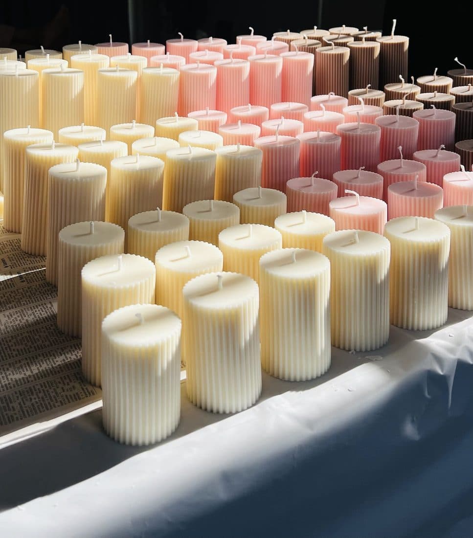 Rows of ribbed pillar candles in cream, blush and mocha, hand-poured for a shop order