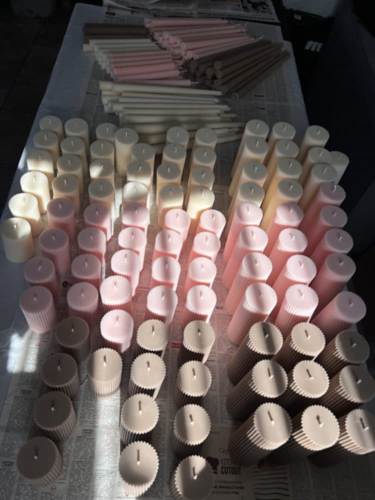 A table of ribbed pillar candles and dinner tapers made in one batch for a shop