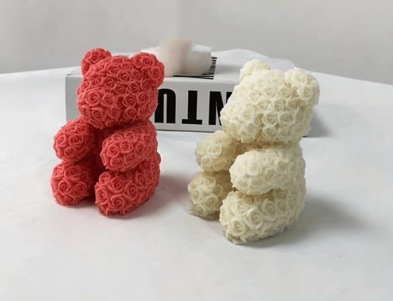 A rose-textured teddy bear candle with a bow, hand-poured in soy wax